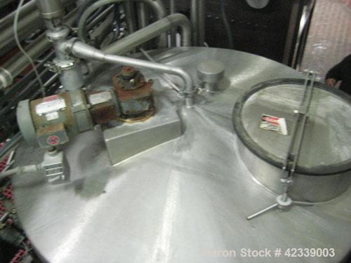 Used Tank, 1,100  Gallon, stainless steel, 66" diameter x 70" straight side.  Vertical, slight cone top, flat / pitched bottom.  Top mounted / off center 1 hp agitator, 1745 rpm, connected to a 2" di...