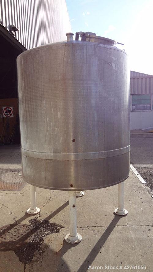 Used Tank, 1000 Gallon, 304 Stainless Steel, Vertical. 66" Diameter x 66" straight side, dished top, coned bottom. Openings top 1-1/2", (2) 2" NPT, (2) 3", 18" man way with cover. 2" Tri-clamp center...