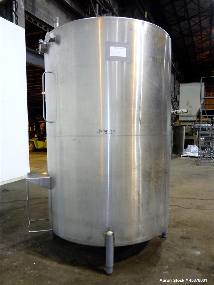 Used Tank, Approximate 1400 Gallons, 304 Stainless Steel, Vertical. Approximate 66" diameter x 93" straight side, dished top, sloped bottom. Top openings 2", 1.5". Side openings 3", 5", 22" man way w...