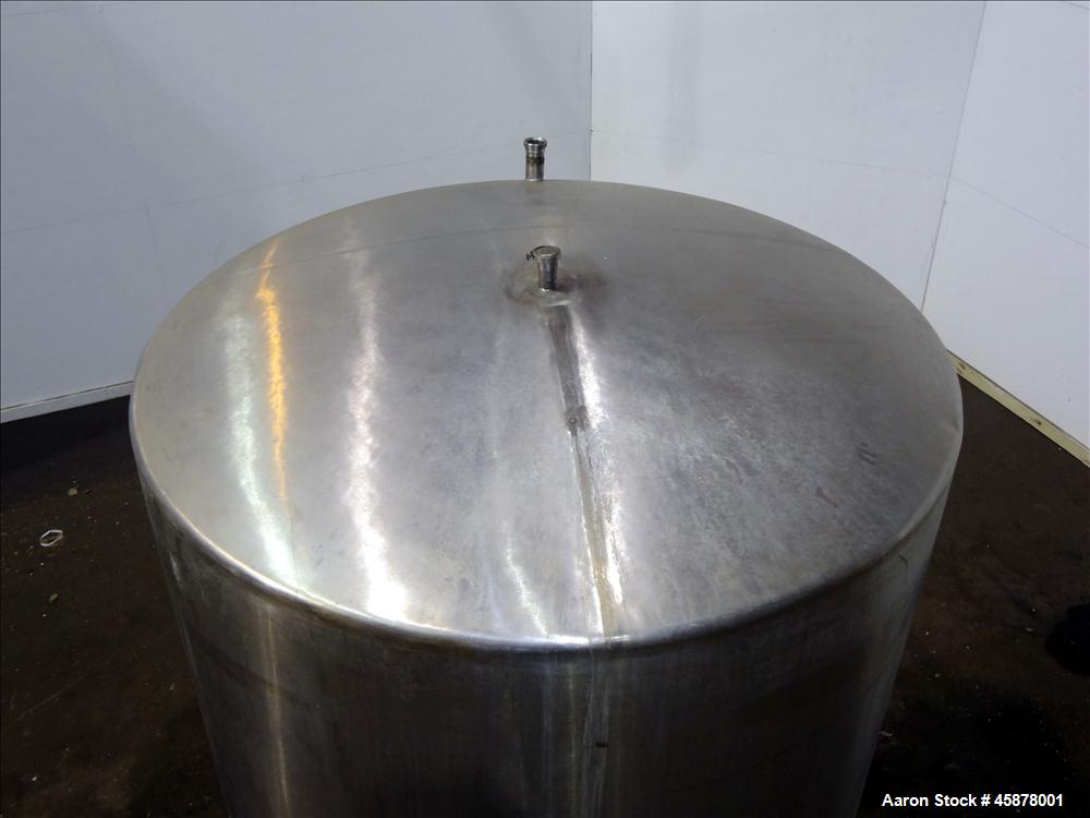 Used Tank, Approximate 1400 Gallons, 304 Stainless Steel, Vertical. Approximate 66" diameter x 93" straight side, dished top, sloped bottom. Top openings 2", 1.5". Side openings 3", 5", 22" man way w...