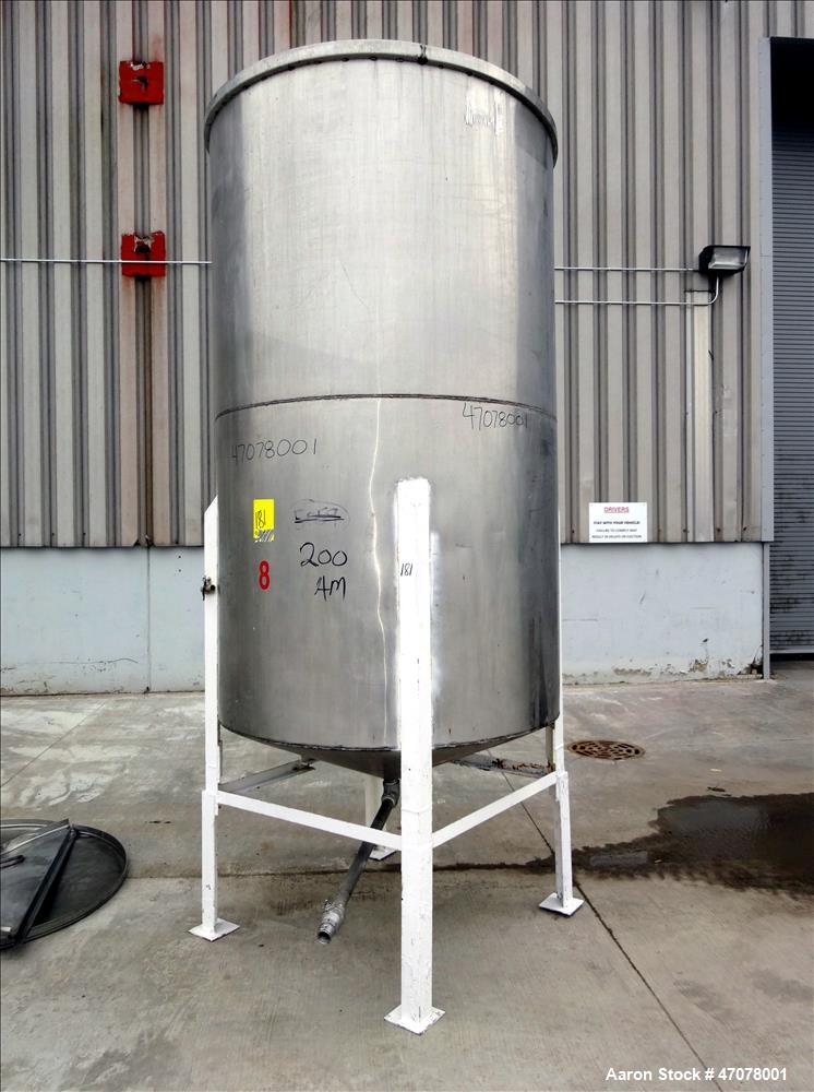 Used Tank, Approximate 1,000 Gallon, 304 Stainless Steel, Vertical. Approximate 56" diameter x 94" straight side. Open top with covers, coned bottom. 2" Center bottom outlet. Mounted on (4) carbon st...