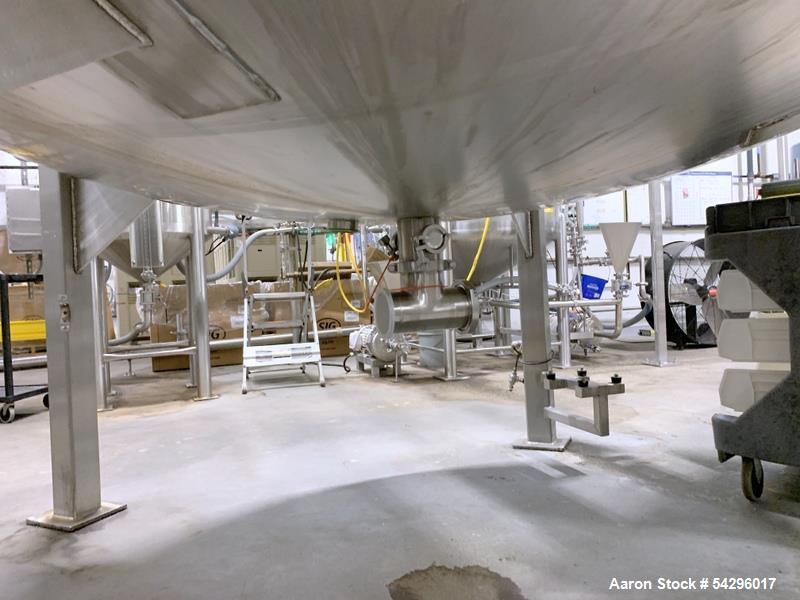 Used Stainless Steel Tank, Approximate 1,000 gallon. Center bottom outlet, side bottom manway, on (4) stainless steel legs.