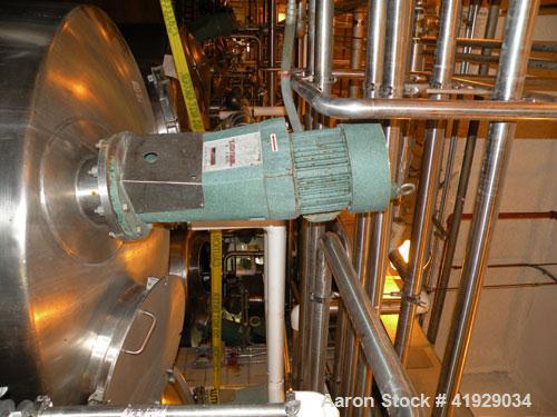 Used Mueller Tank, 2000 Gallon, Model F, stainless steel, vertical. 76" diameter x 106" straight side, dished top and bottom. Off center top entering angled Lightnin agitator, model N33G-300. Driven ...