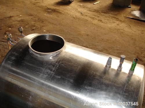 Used Tank, 1200 gallon, stainless steel, horizontal. Approximately 66" diameter x 72" straight side, dished ends. Top manway, end bottom outlet. Mounted on legs.