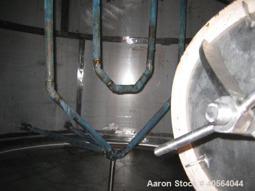 Used 1,800 gallon vertical slope bottom stainless steel tank, 7 ft diameter x 6.3 ft straight height, dished top on legs with side entry manway with swing door cover.