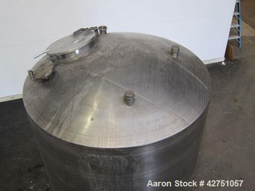 Used Tank, 1000 Gallon, 304 Stainless Steel, Vertical. 66" Diameter x 66" straight side, dished top, coned bottom. Openings top 1-1/2", (2) 2" NPT, (2) 3", 18" man way with cover. 2" Tri-clamp center...
