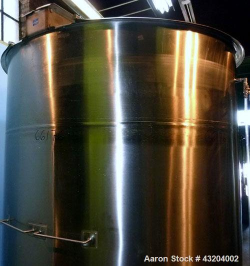 Used Tank, 1,200 Gallon, Stainless Steel, Vertical. Open top with lids, dished bottom. Side mounted level gauge and bridge mounted 1 hp agitator.  1-1/2’’ Center bottom outlet.  Mounted on (4) stainl...