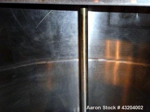 Used Tank, 1,200 Gallon, Stainless Steel, Vertical. Open top with lids, dished bottom. Side mounted level gauge and bridge mounted 1 hp agitator.  1-1/2’’ Center bottom outlet.  Mounted on (4) stainl...