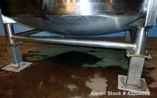 Used Tank, 1,200 Gallon, Stainless Steel, Vertical. Open top with lids, dished bottom. Side mounted level gauge and bridge mounted 1 hp agitator.  1-1/2’’ Center bottom outlet.  Mounted on (4) stainl...