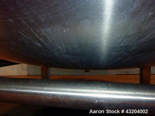 Used Tank, 1,200 Gallon, Stainless Steel, Vertical. Open top with lids, dished bottom. Side mounted level gauge and bridge mounted 1 hp agitator.  1-1/2’’ Center bottom outlet.  Mounted on (4) stainl...