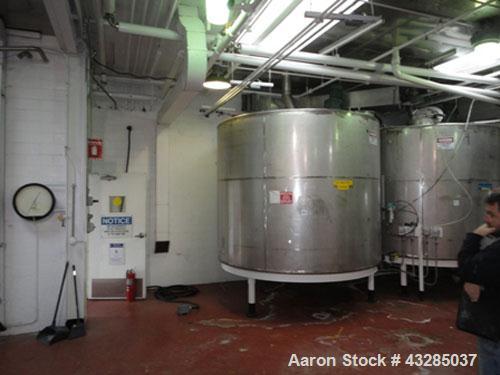 Used Tank, 3000 Gallon, Stainless Steel, Vertical.  Approximately 102" diameter x 84" straight side.  Flat top and bottom.  Off center top entering Lightnin agitator with shaft and prop. Mounted on 4...