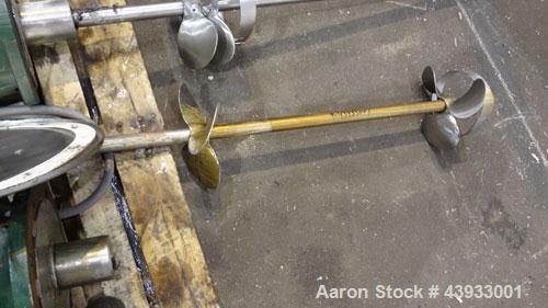 Used Tank, 1050 Gallons, 304 Stainless Steel, Vertical.  Approximately 62” diameter x 82” straight side.  Flat top, sloped bottom.  Off-center top entering Lightnin agitator, model N33G-150.  1-1/2” ...