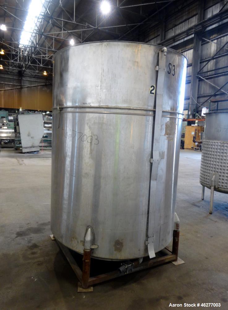 Used Tank, Approximately 1,000 Gallons, 304 Stainless Steel, Vertical. Approximately 62" diameter x 79" straight side. Flat top, sloped bottom. 1-1/2" Off-center bottom outlet. Mounted on (4) legs.