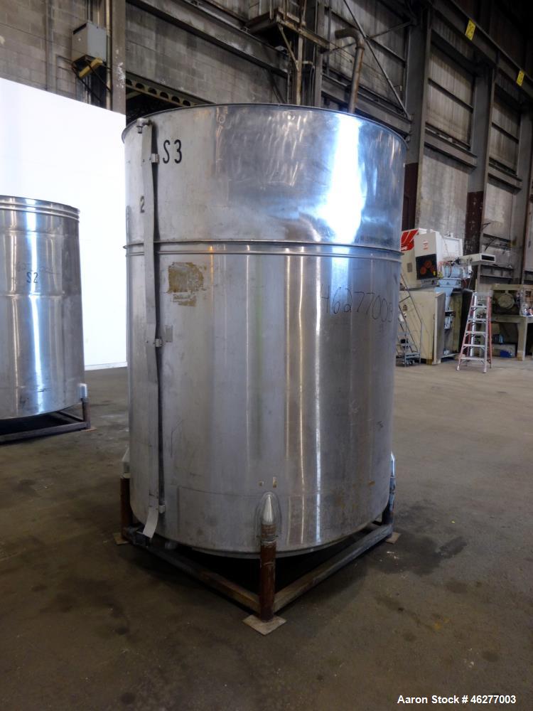 Used Tank, Approximately 1,000 Gallons, 304 Stainless Steel, Vertical. Approximately 62" diameter x 79" straight side. Flat top, sloped bottom. 1-1/2" Off-center bottom outlet. Mounted on (4) legs.