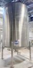 Used Stainless Steel Tank, Approximate 1,000 gallon. Center bottom outlet, side bottom manway, on (4) stainless steel legs.