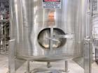 Used Stainless Steel Tank, Approximate 1,000 gallon. Center bottom outlet, side bottom manway, on (4) stainless steel legs.