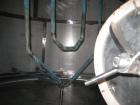 Used 1,800 gallon vertical slope bottom stainless steel tank, 7 ft diameter x 6.3 ft straight height, dished top on legs with side entry manway with swing door cover.