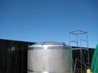 Used 1,800 gallon vertical slope bottom stainless steel tank, 7 ft diameter x 6.3 ft straight height, dished top on legs with side entry manway with swing door cover.