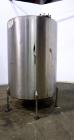 Used Tank, 1050 Gallons, 304 Stainless Steel, Vertical.  Approximately 62” diameter x 82” straight side.  Flat top, sloped bottom.  Off-center top entering Lightnin agitator, model N33G-150.  1-1/2” ...
