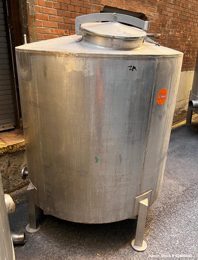 Used Tank, Approximate 650 Gallon, Stainless Steel, Vertical. Approximate 60" diameter x 54" straight side, coned top, sloped bottom. Mounted on 4 stainless legs.