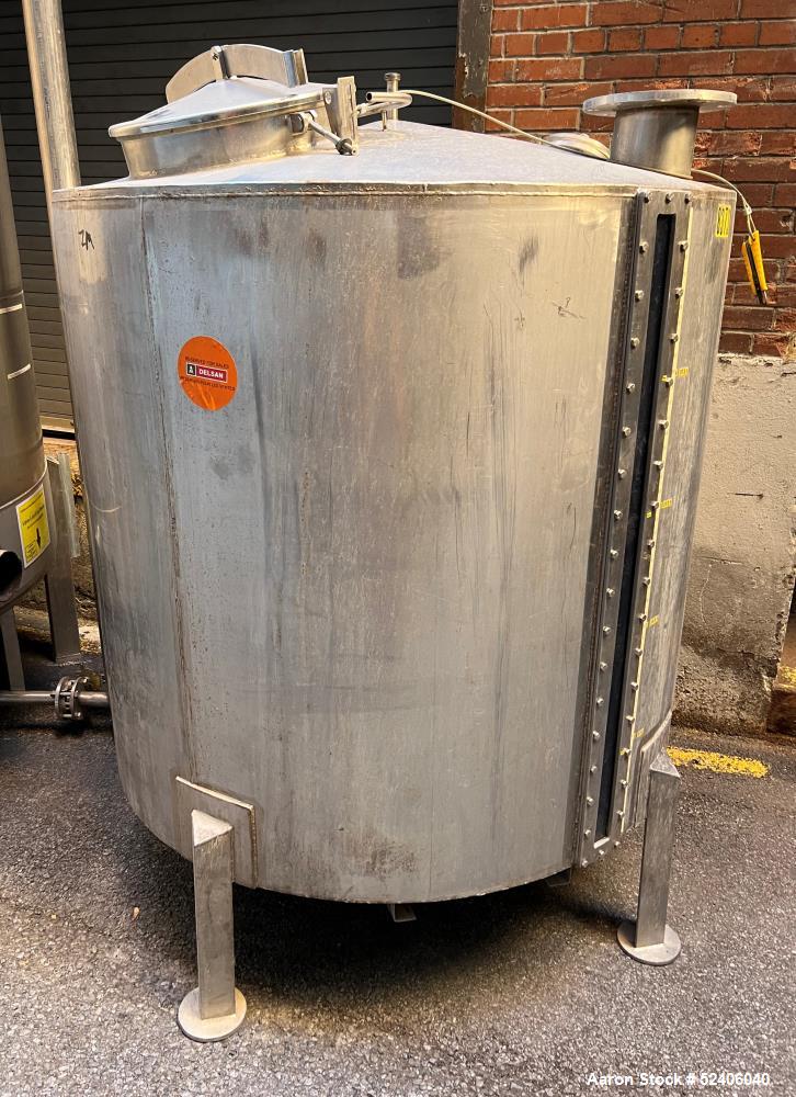 Used Tank, Approximate 650 Gallon, Stainless Steel, Vertical. Approximate 60" diameter x 54" straight side, coned top, sloped bottom. Mounted on 4 stainless legs.