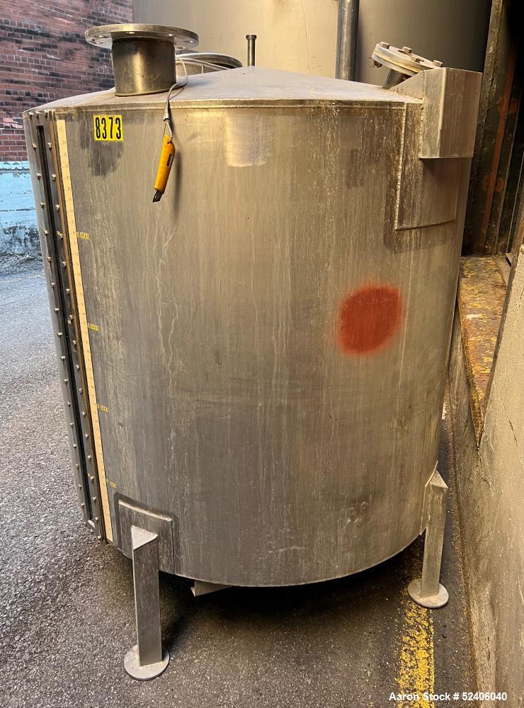 Used Tank, Approximate 650 Gallon, Stainless Steel, Vertical. Approximate 60" diameter x 54" straight side, coned top, sloped bottom. Mounted on 4 stainless legs.