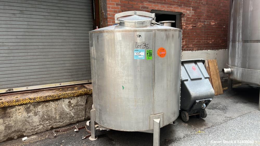 Used Tank, Approximate 650 Gallon, Stainless Steel, Vertical. Approximate 60" diameter x 54" straight side, coned top, sloped bottom. Mounted on 4 stainless legs.