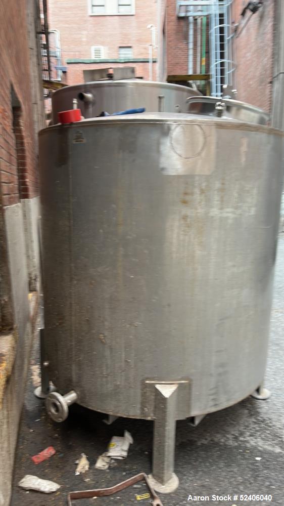 Used Tank, Approximate 650 Gallon, Stainless Steel, Vertical. Approximate 60" diameter x 54" straight side, coned top, sloped bottom. Mounted on 4 stainless legs.
