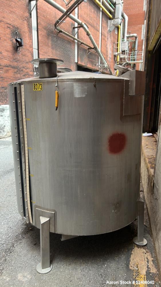 Used Tank, Approximate 650 Gallon, Stainless Steel, Vertical. Approximate 60" diameter x 54" straight side, coned top, sloped bottom. Mounted on 4 stainless legs.