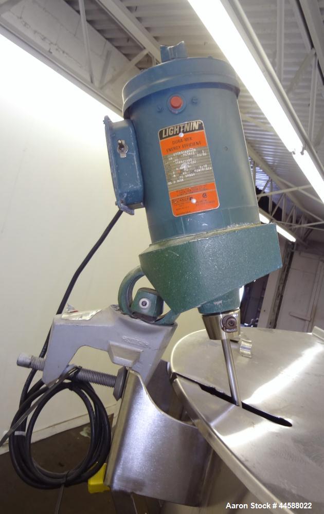 Used Perma-San Tank, 650 Gallons, Model OVS, 316 Stainless Steel, Vertical. Approximately 62" diameter x 51" straight side, open top with (2) 1/3 covers, sloped bottom. Lightnin clamp-on agitator, mo...