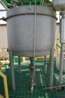Used Tank, Approximate 500 Gallon, Stainless Steel, Vertical. Approximate 60” diameter x 48” straight side, coned top and bottom. Side man way, center bottom outlet. Mounted on (4) stainless steel le...
