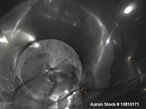 Used 6000 Gallon Stainless Steel Storage Tank. Approximately 94'' diameter, 16' straight wall, side manhole.  Inlets 3-1.5'' threaded 2-3''. Outlets 3'' bolt flange. Tank has large dent in top.