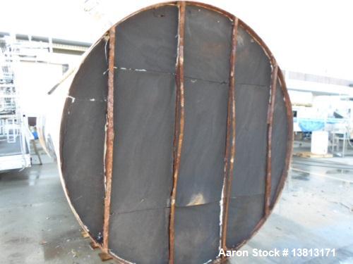 Used 6000 Gallon Stainless Steel Storage Tank. Approximately 94'' diameter, 16' straight wall, side manhole.  Inlets 3-1.5'' threaded 2-3''. Outlets 3'' bolt flange. Tank has large dent in top.