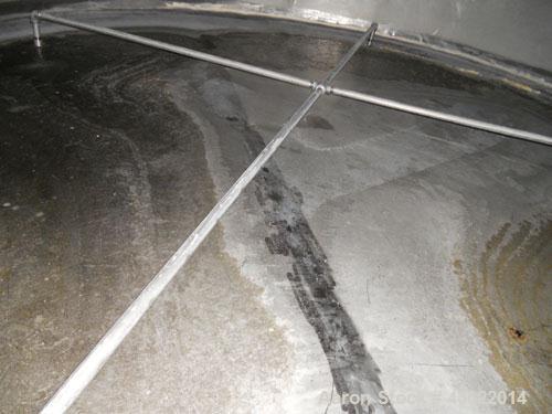 Used Saracco Tank & Mfg Approximately 5,200 Gallon Stainless Steel Storage Tank. Approximately 9' diameter x 11' straight side. Flat bottom and slight cone top. Various top openings including a 17" m...
