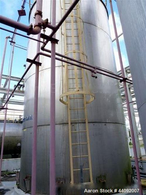 Used Alonso & Carus 25,000 Gallon Stainless Steel Vertical Storage Tank. 13'6" Nominal Diameter x 24' Nominal Height. Flat Bottom & Dish Top. 24" Side Manway with Bolt on Cover. Top Manway with vario...