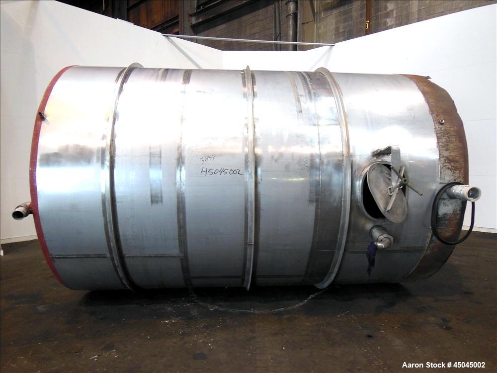 Used Tank, 5,000 Gallon, 304 Stainless Steel, Vertical. Approximate 102" x 142" straight side, slight coned top, sloped bottom. Openings top 3", 3-1/2", 1-1/2", side 16" x 20" oval man way with cover...