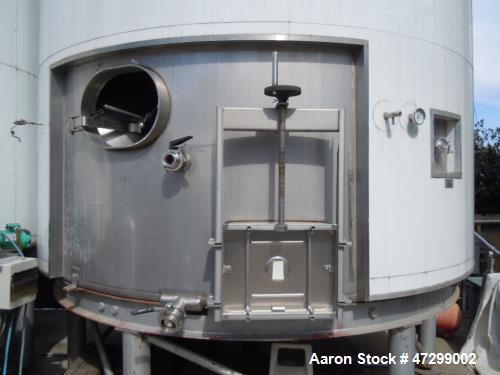 Used 7,200 Gallon Stainless Steel Tank. Approximately 14' tall (with stands approximately 17'), 10' diameter, 2 x 4ft. jackets for glycol / coolant. Cooling channels built into floor. Inverted cone f...