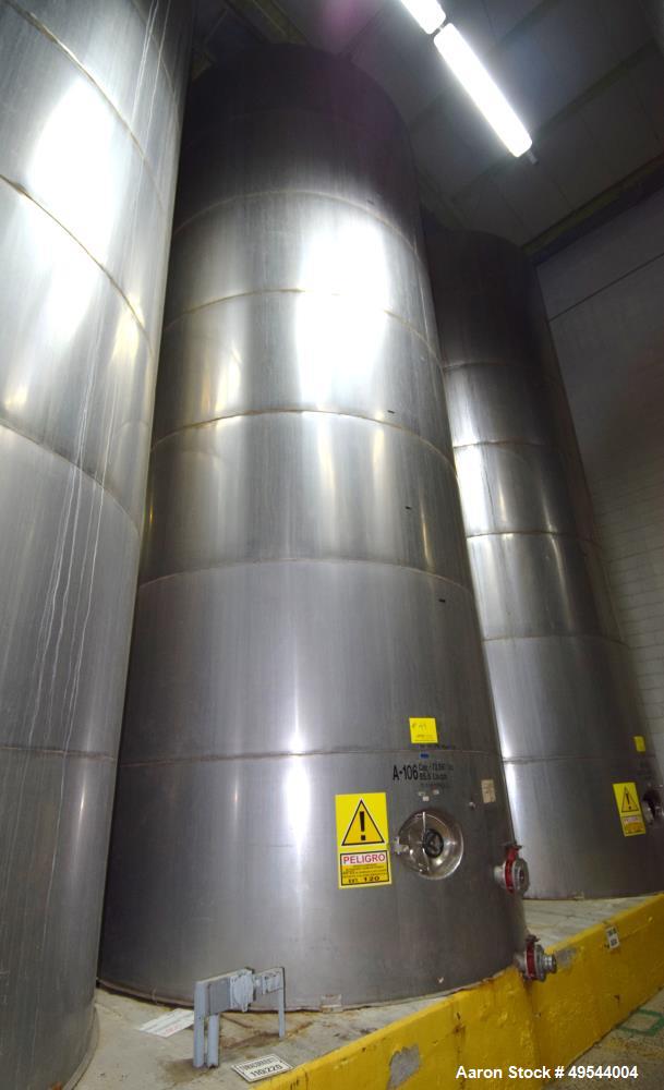 Used Tank, Approximate 19,500 Gallon, 14 Gauge Stainless steel, Vertical. Approximate 130” diameter x 336” straight side, coned top, 7” sloped bottom. Openings top 16” man way with cover and approxim...