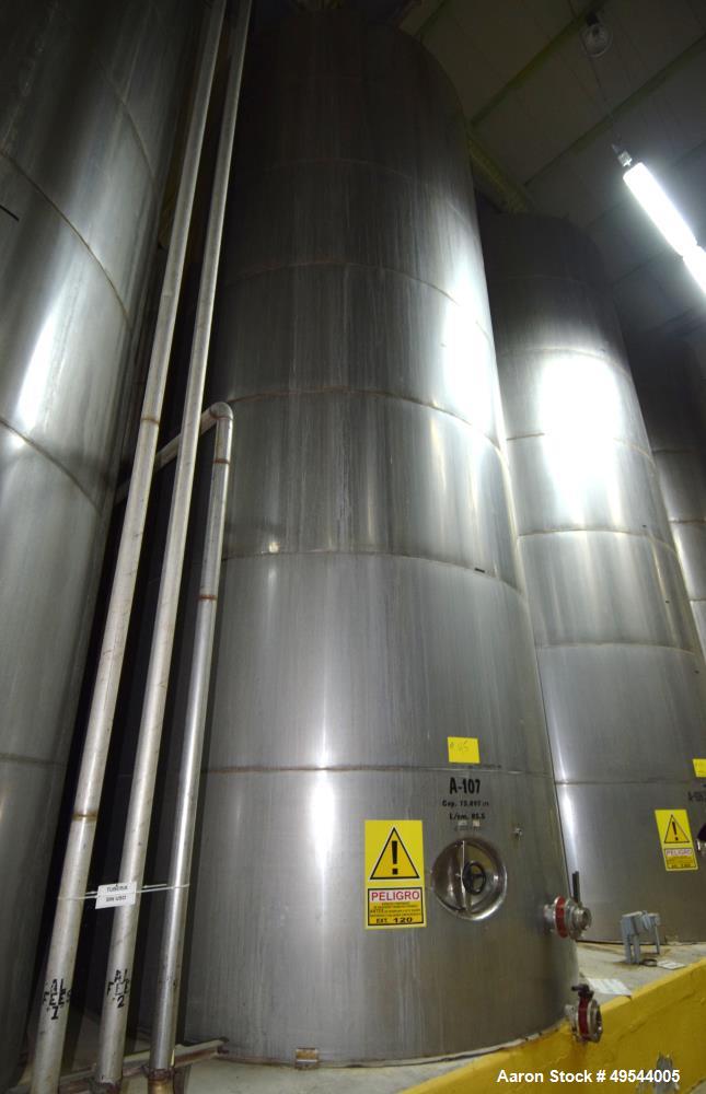 Used Tank, Approximate 19,500 Gallon, 14 Gauge Stainless steel, Vertical. Approximate 130” diameter x 336” straight side, coned top, 7” sloped bottom. Openings top 16” man way with cover and approxim...