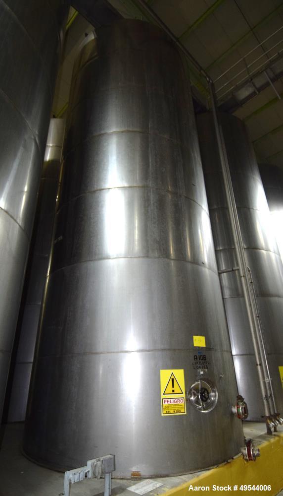 Used Tank, Approximate 19,500 Gallon, 14 Gauge Stainless steel, Vertical. Approximate 130” diameter x 336” straight side, coned top, 7” sloped bottom. Openings top 16” man way with cover and approxim...