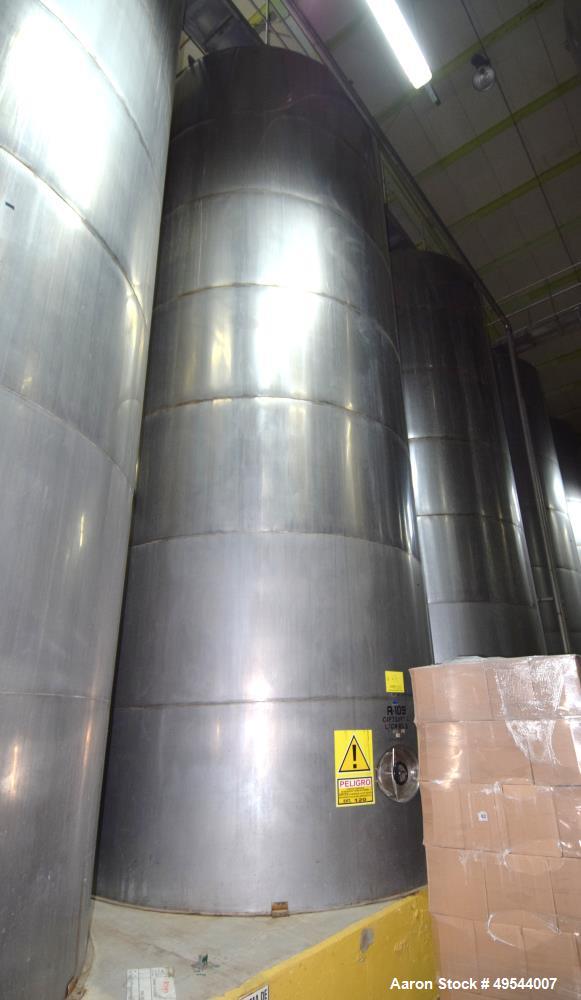 Used Tank, Approximate 19,500 Gallon, 14 Gauge Stainless steel, Vertical. Approximate 130” diameter x 336” straight side, coned top, 7” sloped bottom. Openings top 16” man way with cover and approxim...