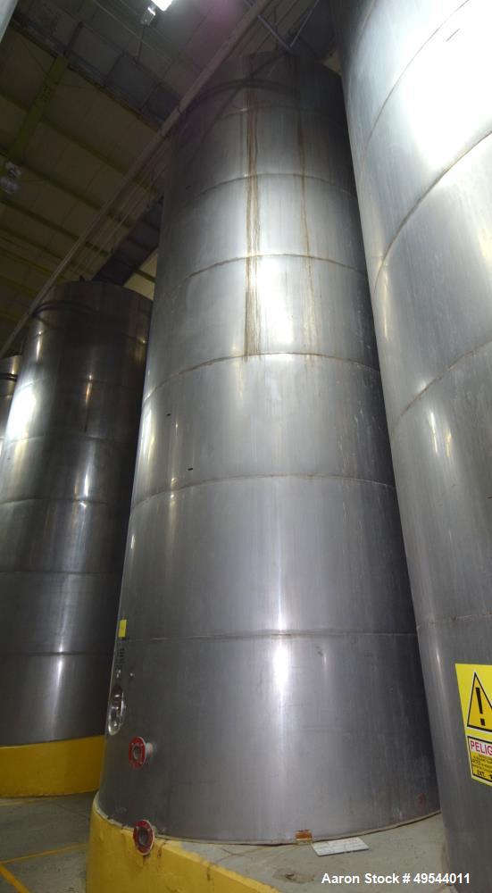 Used Tank, Approximate 19,500 Gallon, 14 Gauge Stainless steel, Vertical. Approximate 130” diameter x 336” straight side, coned top, 7” sloped bottom. Openings top 16” man way with cover and approxim...