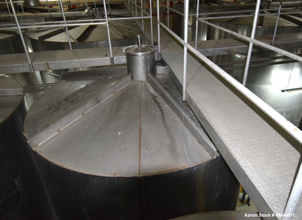 Used Tank, Approximate 19,500 Gallon, 14 Gauge Stainless steel, Vertical. Approximate 130” diameter x 336” straight side, coned top, 7” sloped bottom. Openings top 16” man way with cover and approxim...