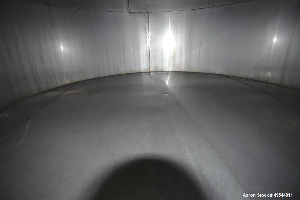Used Tank, Approximate 19,500 Gallon, 14 Gauge Stainless steel, Vertical. Approximate 130” diameter x 336” straight side, coned top, 7” sloped bottom. Openings top 16” man way with cover and approxim...