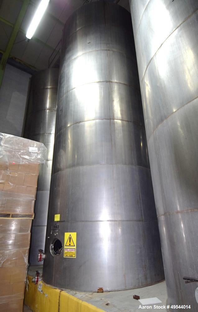 Used Tank, Approximate 19,500 Gallon, 14 Gauge Stainless steel, Vertical. Approximate 130” diameter x 336” straight side, coned top, 7” sloped bottom. Openings top 16” man way with cover and approxim...