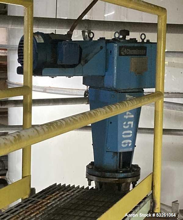 Used Approximate 8000 gallon Stainless Steel Mixing Tank With Centrifugal Pump, V-4506. Flat top with misc. top inlets. Cone bottom with center bottom outlet. Insulated shell. Top entering Chemineer ...