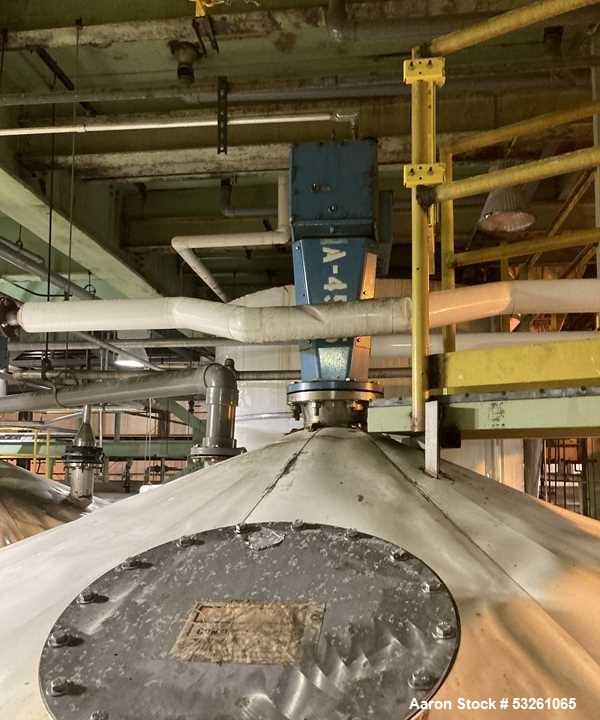 Used Approximate 8000 gallon Stainless Steel Mixing Tank With Centrifugal Pump, V-4505. Flat top with misc. top inlets. Cone bottom with center bottom outlet. Insulated shell. Top entering Chemineer ...