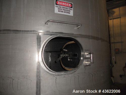Used Krenz Approximately 10,000 Gallon Stainless Steel Storage Tank. Approximately 12' diameter x 12' straight side. Flat bottom and slight cone top. Various top openings including a 17"manway with c...