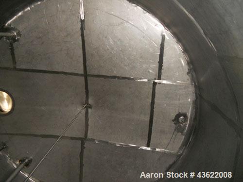 Used Krenz Approximately 10,000 Gallon Stainless Steel Storage Tank. Approximately 12' diameter x 12' straight side. Flat bottom and slight cone top. Various top openings including a 17"manway with c...