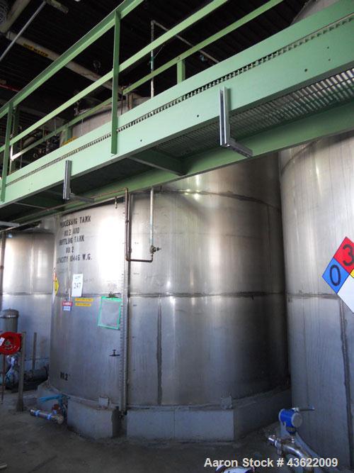 Used Krenz approx. 10,000 gallon stainless steel storage tank. Approx. 12' diameter x 12' straight side. Flat bottom and slight cone top. Various top openings including a 17"manway with cover. 3" Thr...